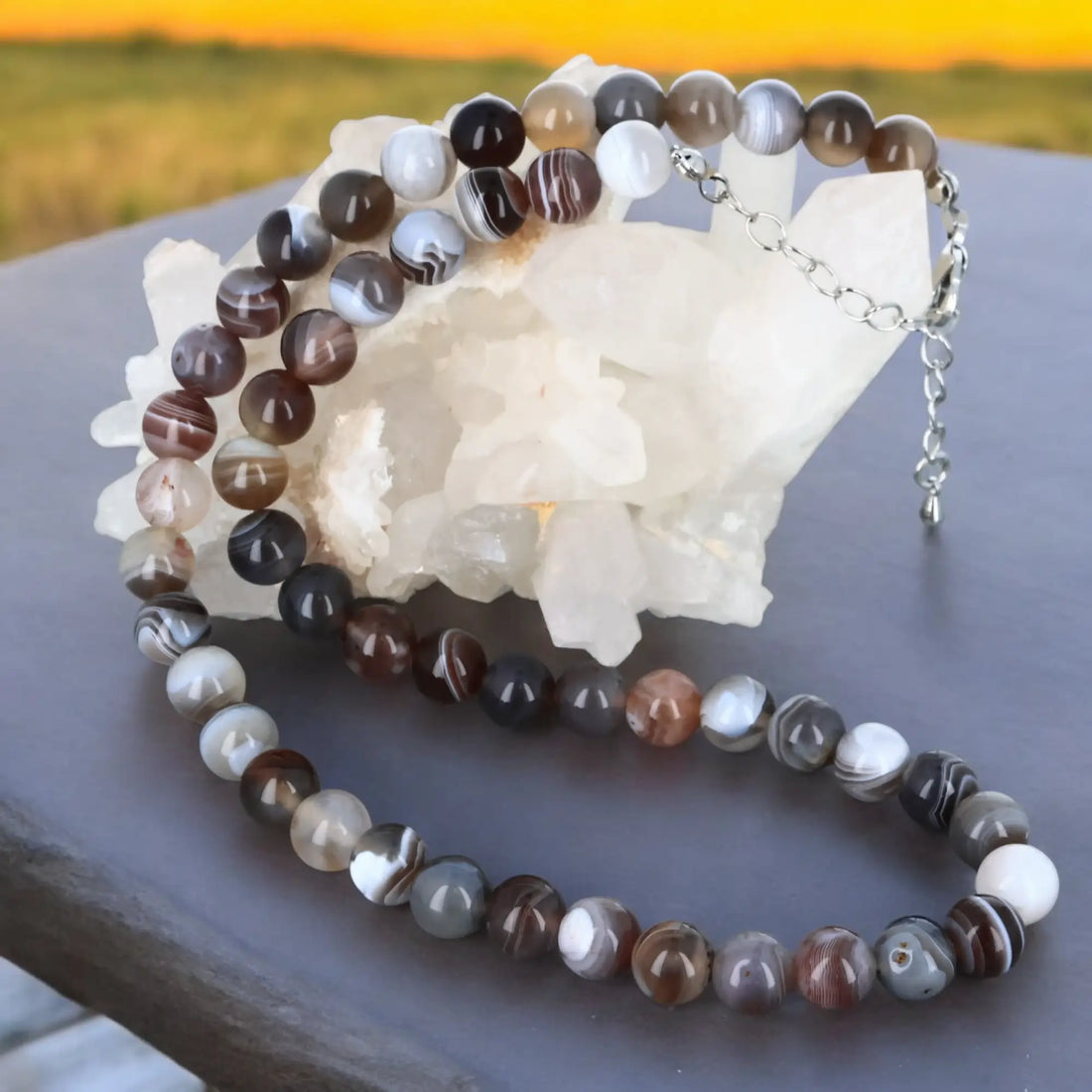 Collier en perle de pierre en agate reposant délicatement sur un fond blanc, mettant en valeur ses couleurs vibrantes et ses motifs naturels